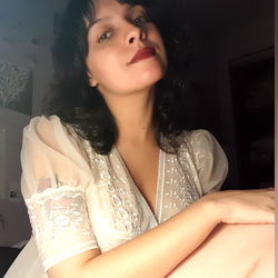 A woman in a lace top posing for the camera.