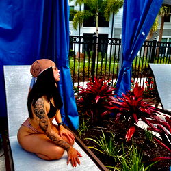 A Model Posing for an OnlyFans Photoshoot at a Hotel Pool