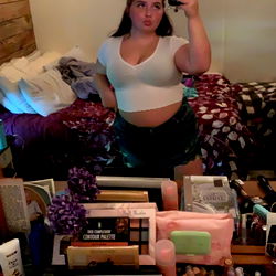 Laid-back Model in Her Element, Surrounded by Personal Items and Beauty Products