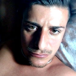 A Shirtless Man Resting on Pillows