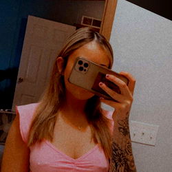 Ash, a captivating OnlyFans model in a pink cropped top and tattoos