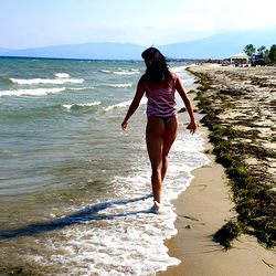 A beautiful beach scene with a model walking on the shore