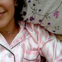 A Woman Smiling and Taking a Selfie in Bed