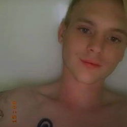 Caucasian male in a bath, tattooed bicep