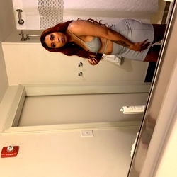 Model Taking a Selfie in Bathroom Mirror