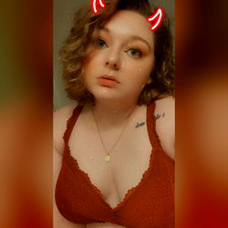 Ari, a model on OnlyFans, strikes a seductive pose in red lingerie.