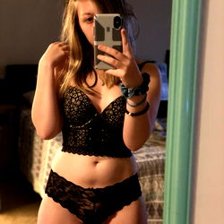 Athena, a lingerie model from Orlando,FL, takes a mirror selfie in her bedroom