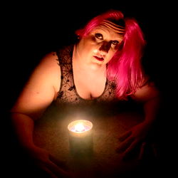 Striking pose in a dimly lit room, Alex Apple embodies the enigmatic allure of onlyfans models.