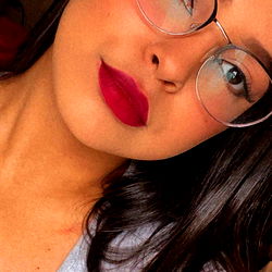 A young woman in a casual setting with makeup on her lips.