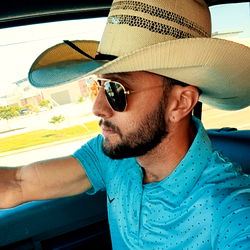 Dalton Reckless, a Texas-based model and influencer, showcasing his cowboy hat and sunglasses style while driving.
