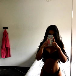 Amelia, an OnlyFans model sharing a selfie on a bed