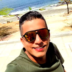 A man with a smile standing by the ocean