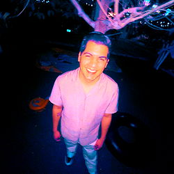 A young adult male posing for a selfie at night