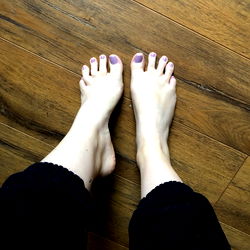 Arch Queen's Bare Feet on a Wooden Floor