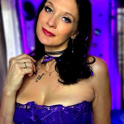 Ash, a striking OnlyFans model in a purple dress