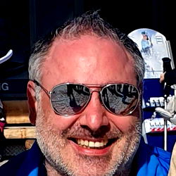 A man posing for a photo outdoors