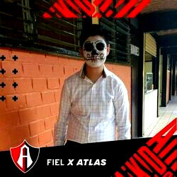 Eduardo Antonio posing with a skull mask in front of a building