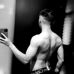 Fit and Muscular Man Taking a Mirror Selfie in Gym Wear