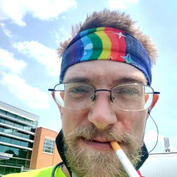 Man in Rainbow Bandana with Cigarette and Tie-Dye Shirt