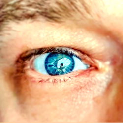 A man with a striking blue eye capturing his surroundings from Amsterdam