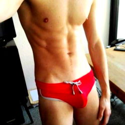 Fit Model Austin Zafir Showcasing Six Pack Abs in Red Swimsuit