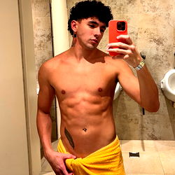 A shirtless man in a bathroom mirror