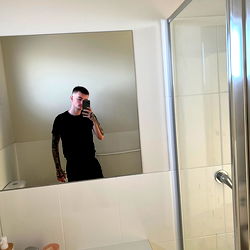 Man in Black Shirt in Bathroom Mirror