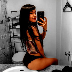 Rose, a captivating OnlyFans model posing confidently in a bathroom