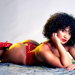 Seductive Karlye, the OnlyFans model posing in a red bodysuit