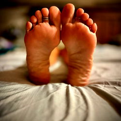 Footlady4u2 showcasing her feet on a bed