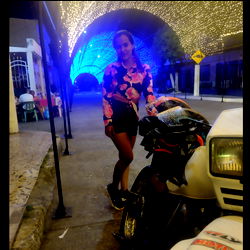 Ale Mora, posing on a sidewalk at night