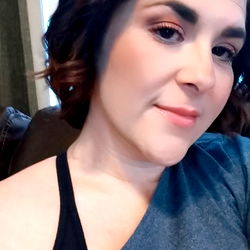 Woman in a casual outfit with a cropped top, wearing black hair accessories.