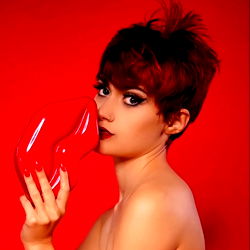 Red-haired model Ann Mossy in a vibrant red setting