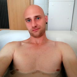 Shirtless Man with Bald Head Taking Selfie in Bathtub