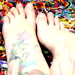 Beautifully Tattooed Feet Against a Multicolored Carpet