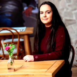 A Woman Posing for a Photo at a Cafe