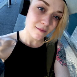 Young Adult Woman with Tattoos, Headphones and Cap
