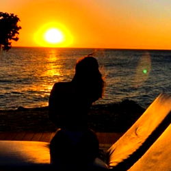 Model Poses Tranquilly by Ocean Sunset