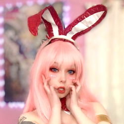 Anime-inspired cosplay featuring an Angel model wearing a vibrant pink bunny costume with red ears and a playful, youthful vibe.