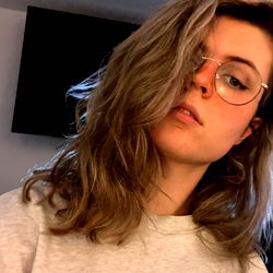 Mia Stevens, a young woman with curly hair and glasses