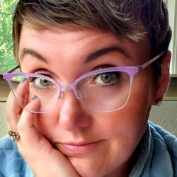 A woman wearing glasses and a blue top