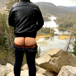 Fitness enthusiast showcasing his toned abs and back muscles in nature