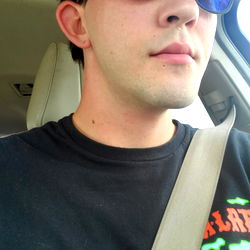 A man in a car, donning sunglasses