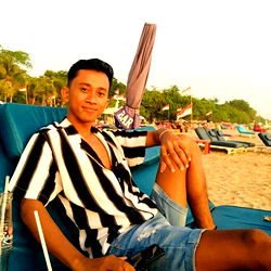 A person posing for a photo at the beach