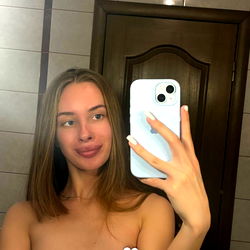 A Woman in a Tank Top Taking a Mirror Selfie