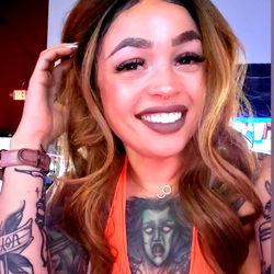 Allie Nichols: Smiling Model with Tattoos, Orange Top, and Bold Lip Color