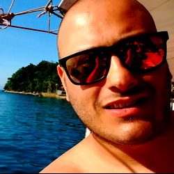 A Shirtless Man with Short Hair in a Sunglasses-Reflective Environment