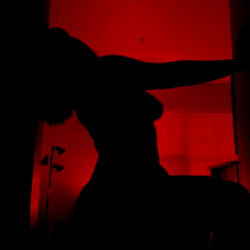 OnlyFans Model Photo: Rose, Silhouetted in a Room with Red Light and Shadow