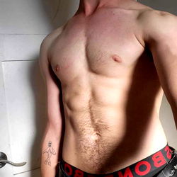 Sculpted Fitness Model Showcasing Shirtless Abs and Tattoos