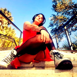 A Woman in Vintage-Style Clothing Posing with Skate Shoes on Steps